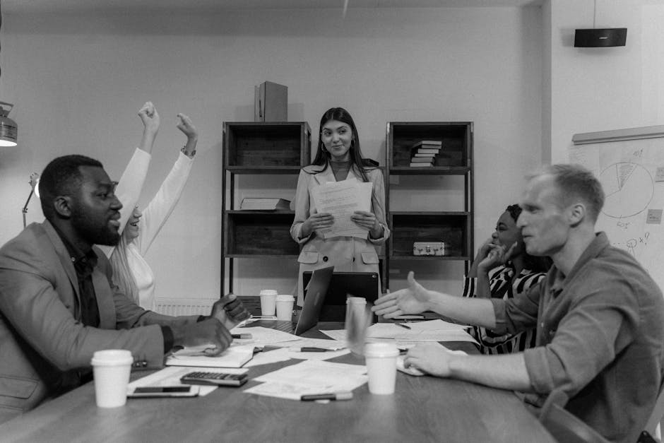 A diverse group of adults having an engaged business meeting indoors with teamwork and discussion.