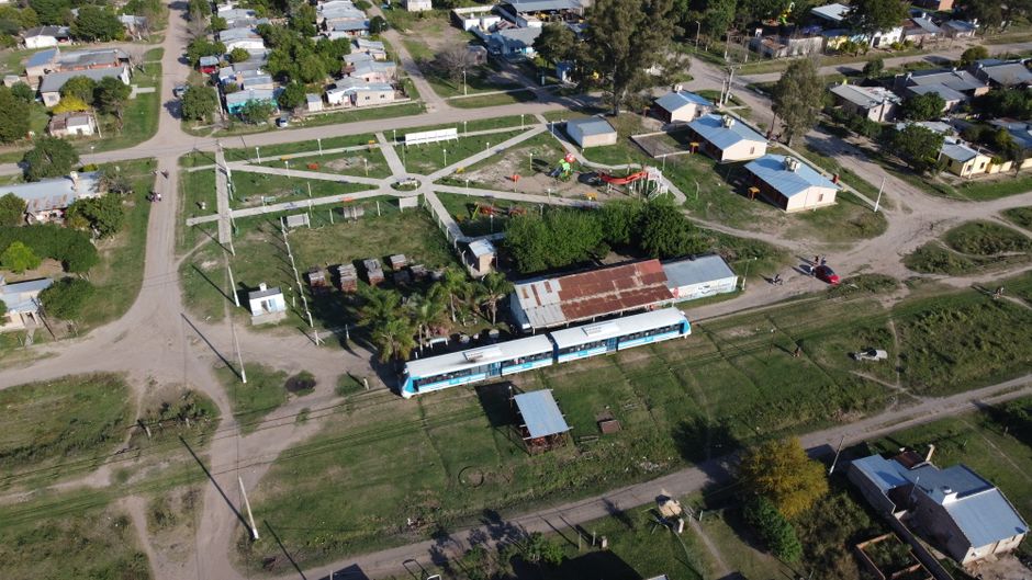 Aerial view of Cote-lai, Chaco, featuring a train and small town layout on a sunny day.