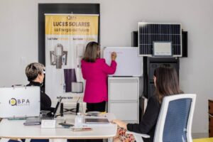 A team engaged in brainstorming solar energy solutions with panels and a whiteboard in an office.